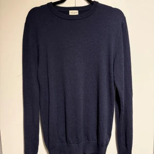 Mörkblå stickad tröja John Henric - Snygg mörkblå stickad tröja från John Henric i storlek S. Tröjan har rund hals, ribbade muddar och långärmad passform. Perfekt för dig som gillar stilrena och klassiska plagg med en chill vibe.