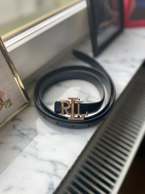 Lauren Ralph Lauren skärp  - Säljer ett skräp från Lauren Ralph Lauren, den är 110cm lång och 2,3cm i bredd den här också 10 hål för att justera storleken. 