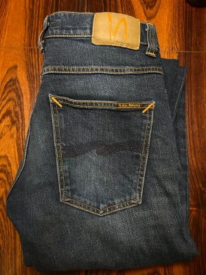 Nudie Jeans Grim Tim mörkblå jeans - Mörkblå jeans från Nudie Jeans, modellen Grim Tim. Knappt använda