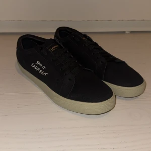 Svarta Saint Laurent sneakers - Tjenare! Säljer ett par riktigt snygga och eftertraktade skor från saint Laurent. Skorna är 10/10 skick och därför helt nya. De är i storlek 42 och tillbehör saknas. Pris 2199kr