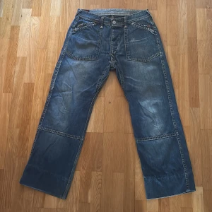 Evisu jeans - Ett par Evisu herrjeans i storlek 32. Ganska baggy i modellen, straight leg. Själva Evisu loggorna på bakfickorna är ganska utsuddade, är man kreativ går det garanterat att fixa det. Annars i bra skick, inga defekter. 