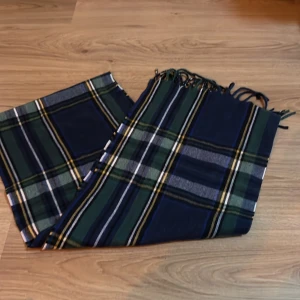 Rutig halsduk från Pull&Bear - Jätte fin halsduk från Pull&Bear. Aldrig använt den. Perfekt nu till kallare dag. Ny pris 230kr mitt pris 200kr (eftersom den aldrig varit använd) skriv vid frågor eller mer bilder. 168 cm x 33 cm.