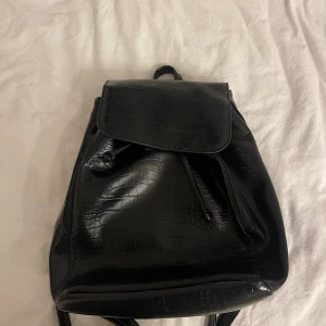 Svart ryggsäck med krokopräglad yta - Har använd par gånger inköpt från glitter 