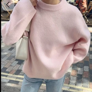 Ljusrosa stickad tröja från Amisu - Supermysig ljusrosa stickad tröja från Amisu med rund halsringning och ribbade muddar. Tröjan har en loose passform och är perfekt att slänga på sig till jeans. Enkel och stilren design som är lätt att matcha.