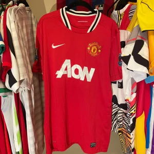 Manchester United 11/12 Nike tröja Äkta,  strl L - Riktigt snygg Manchester United matchtröja från säsongen 11/12 med Barclays Premier League Champions-märke på ärmen. Röd med vit Aon-logga, klubbmärke och Nike swoosh på bröstet. Kragen är vit och svart, materialet är ventilerande polyester. Tröjan är i mycket bra skick och i storlek L. Äkta