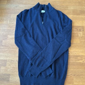 Marinblå stickad tröja John Henric - Säljer en marinblå stickad tröja från John Henric i storlek M. Tröjan har half zip-dragkedja vid halsen och är långärmad. Perfekt för lager-på-lager och snygg till jeans eller chinos.