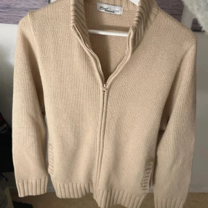 NeXT full zip kofta - Säljer en beige stickad kofta från Next. Mycket bra skick och inga defekter på den, storlek M men passar S också. Säljs för 299kr och kontakta mig om du har frågor.