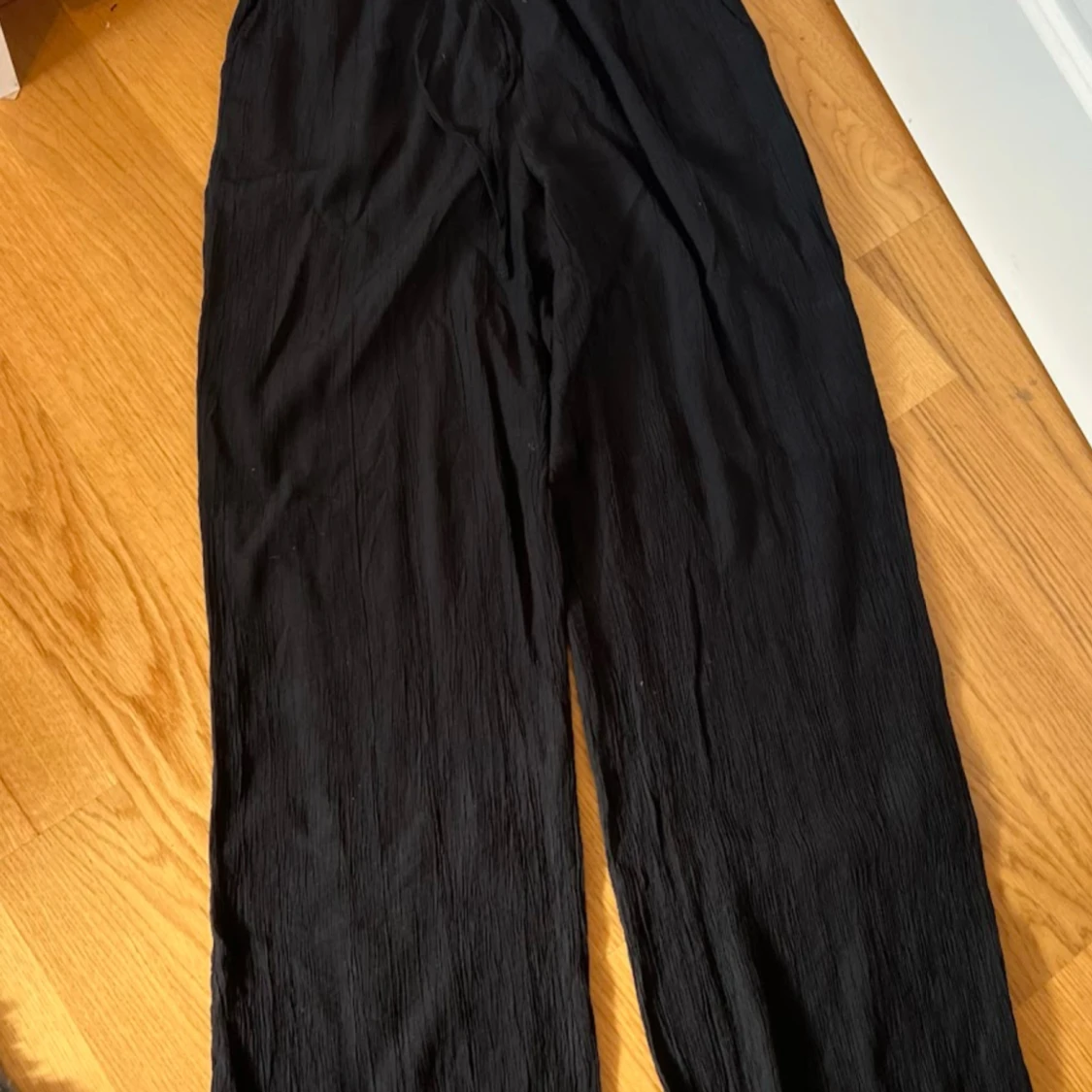 Svarta vida byxor i crinkle-tyg