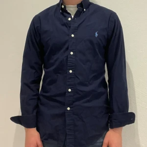 Marinblå Ralph Lauren skjorta  - Marinblå Ralph lauren skjorta || Storlek S (Slim Fit) || Skjortan är i bra skick || Modellen på bilden är 170cm och väger 62kg || Tveka inte på att höra av dig vid frågor eller funderingar 