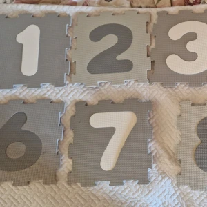 Sifferpusselmatta i skum, 1-9 - Sifferpusselmatta i mjukt skum, siffrorna 1-9. Perfekt för lek och inlärning. Lätt att montera och ta isär. Grå och vita nyanser. Viss användning syns såsom lite små fläckar som ej provat att få bort samt ett litet nertryckt ifrån ett t.ex nagel men i fint skick, inga skador.