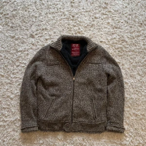 Stickad fleece från Jack & Jones - Snygg grå/brun stickad och fodrad jacka från Jack and Jones. Den är tjock o varm perfekt inför vintern. Står storlek XL men skulle säga att den sitter som en L. Den är i använt skick och stickningen har gått upp lite i slutet av ärmen, ena fickan har också ett hål men det går inte igenom helt. Tveka inte på o skriva vid fler frågor!