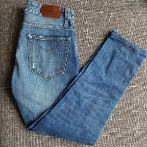 Blå jeans från NN07, 29/32 - Snygga blå jeans i klassisk femficksmodell. Jeansen har en rak passform och är tillverkade i slitstarkt denim med snygga slitningar och kontrastsömmar. Perfekta för dig som gillar en tidlös och avslappnad stil.