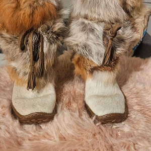 Feta pälsboots med äktapäls från Winna, storlek 38 - Unika boots från Winna med fluffig päls i beige, brun och grå toner. Snygga detaljer med mockaband och tofsar. Sulan är robust och brun, perfekt för kalla dagar. Bootsens ovandel är täckt av päls och har en platt sula med fyrkantig tå. Nypris ca 2000kr      Priset kan diskuteras vid snabb affär