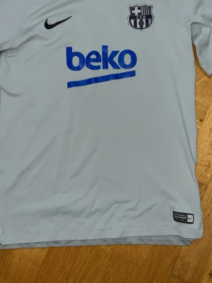 Barcelona tröja - 🔥 Nike FC Barcelona tränings­tröja – Dri-FIT – Youth XL (158–170 cm) 🔥  Stilren och sportig FC Barcelona-tröja från Nike i snygg grå färg. Tillverkad i Dri-FIT-material som andas och håller dig torr under träning. Perfekt för fotboll, gym eller som vardagströja för alla Barça-fans.  ✔ Officiellt FC Barcelona-märke ✔ Original Nike ✔ Lätt och ventilerande material ✔ Bekväm passform   Se bilder för detaljer. Perfekt present elle