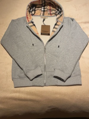 Burberry hoodie - Stilren Burberry hoodie i mjuk premiumbomull som kombinerar komfort och lyx. Den ikoniska designen ger ett exklusivt uttryck och passar perfekt både till vardags och för en mer uppklädd streetwear-look. Ett tidlöst plagg för dig som vill bära kvalitet och stil. Pris kan diskuteras.