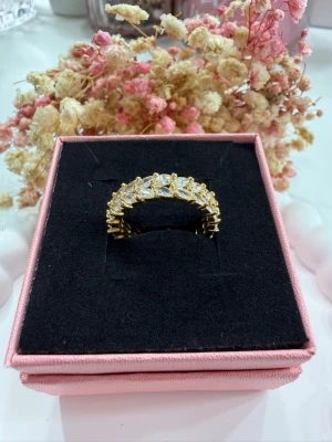 Justerbar ring - Ge din look en lyxig touch med en 18K guldpläterade ring med strass – perfekt för både vardag och fest! 💛 Ringen är justerbar, vilket gör att den passar alla storlekar utan krångel. ✔️  💍 Specifikationer: • 18K guldplätering • Glittrande strass-stenar • Justerbar storlek • Trendig & elegant design