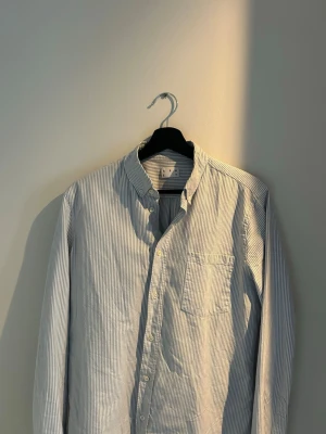 Randig Oxfordskjorta från Asket - Säljer en klassisk blåvit randig Oxfordskjorta från Asket i storlek M Long. Hör av er vid någon fråga!