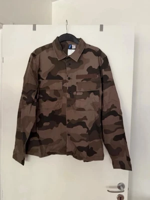 Militärjacka med tryck  - Storlek L. Aldrig använd. 