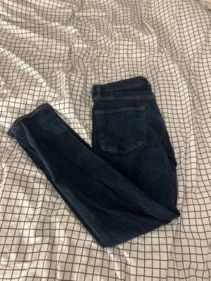 Mörkblå jeans från Lager 157 - Säljer ett par mörkblåa jeans från Lager 157 med klassisk femficksdesign och snygga kontrastsömmar. Jeansen har normal midja och raka ben, tillverkade i slitstarkt denimtyg som sitter riktigt bra. Perfekta till en avslappnad look.