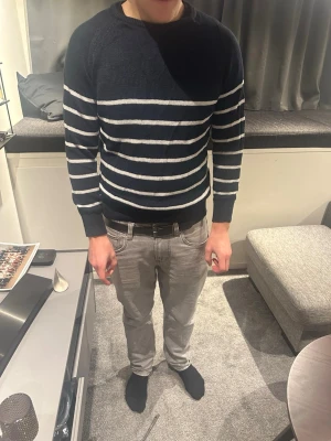 Marinblå randig linnetröja Suitsupply - Säljer en marinblå stickad tröja från Suitsupply i storlek L. Tröjan är gjord i linne och har vita horisontella ränder över hela plagget. Klassisk rund halsringning och ribbade muddar vid ärmslut och nederkant. Perfekt för dig som gillar stilrena basplagg. Nypris ligger 1799kr 