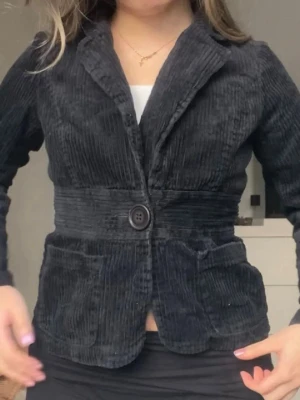 Kavaj/kofta - Kavaj i Manchester tyg. Barnstorlek 12år men passar xxs/xs. Rätt liten i storlek. Snygg detalj i midjan som gör så att kavajen blir figursydd