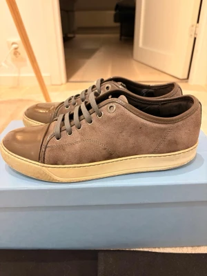 Gråa sneakers från Lanvin storlek 41 - Säljer ett par gråa lanvin i storlek 41, de har använts ett par gånger men funkar fortfarande perfekt, lite repor på lacken men det är inget man märker av. 100% äkta 