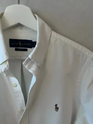 Ralph Lauren Skjorta - Riktigt stilig Ralph Lauren skjorta i dunder skick med vit färg. Skjortan är i storlek S och den mest eftertraktade modellen Slim Fit. Vid frågor eller funderingar tveka inte på att höra av er! 😊