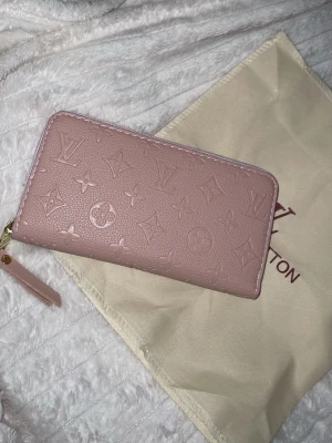 Rosa plånbok | Inspirerad  - Säljer en snygg rosa plånbok i skinn med klassiskt monogrammönster. Plånboken har dragkedja i guld, flera fack för kort och myntfack med dragkedja. Perfekt storlek för att ha med sig överallt. Dustbag medföljer!!❤️Se alla bilder (bruna sträck mellan facken) (inget som påverkar)!❤️gåva vid varje köp! Fynda fynda! Öppen för prisförslag vid fler köp!