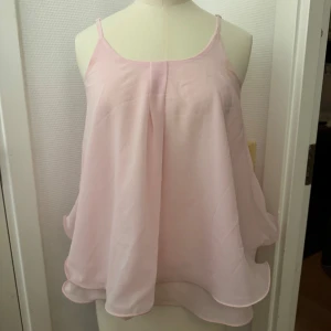 Ljusrosa volangig topp - Säljer en superfin ljusrosa topp med tunna axelband och dubbla lager tyg som ger en snygg volang-effekt. XS/S Toppen är luftig och har en flowy passform. Hämtas i Hägersten om du vill slippa frakt. Var även uppmärksam på när Plick erbjuder fraktfritt ibland på dyrare plagg. Följ mig gärna. Har mycket att lägga ut i olika storlekar! 