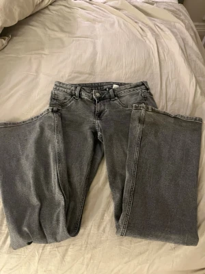 Grå bootcut jeans från H&M Divided - Säljer ett par gråa bootcut jeans från H&M Divided i storlek 38. Jeansen har klassisk femficksmodell, normal passform över låren och lätt utsvängda ben. Materialet är mjukt denim i bomull och färgen är snyggt tvättad grå. Priset går att diskutera 💞