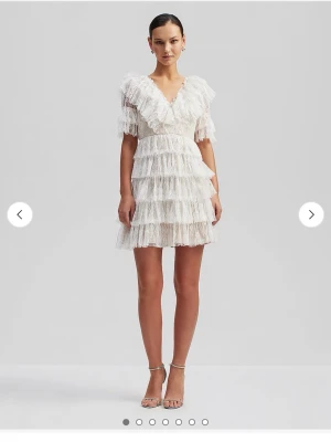 Vit volangklänning i spets - Superfin kort vit klänning med flera lager volanger och spetsdetaljer. Djup v-ringning både fram och bak, korta ärmar och markerad midja. Perfekt för dig som gillar romantisk och trendig stil. Klänningen är by Malina och köptes för 2 800kr. Den är använd endast EN gång, under min student dag. Storlek S och är True to Size. Pris kan diskuteras men kommer inte sälja den mycket billigare då den på riktigt bara är använd en gång, så är absolut som ny! Men skriv för fler bilder och om ni har frågor.