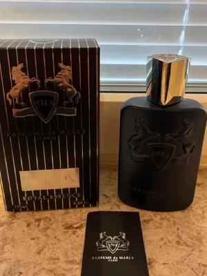Parfums de Marly Layton 125ml - Lyxig parfym från Parfums de Marly, modellen Layton Royal Essence. Flaskan är matt svart med silverfärgat lock och har en elegant, stilren design med reliefmönster av hästar och sköld. Förpackningen är svart med vita ränder och silverdetaljer. Innehåller 125 ml. Kan tänka byta min creed althair och ysl myself mot ett par loubs eller valentino har flera parfymer jag kan byta mot ett par skor 
