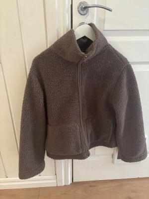 Brun teddyjacka med dragkedja - otroligt mysig och fin brun teddyjacka🤎 jackan har två fickor på främre sidan som är otroligt lämpliga!😍teddyjackan har även en hög krage som gör att man håller värmen inne bra🙈💖