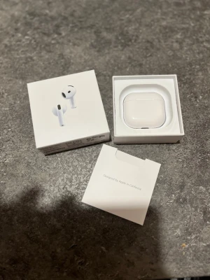 Apple AirPods 4 med laddningsetui - I väldigt fint skit med bra ljud *Defket: brusredusering fungerar ej* Säljer ett par vita Apple AirPods 4 med trådlöst laddningsetui. Snygg och stilren design i blank plast, perfekt för dig som vill ha grymt ljud och smidig anslutning till din iPhone. Kommer i originalförpackning.