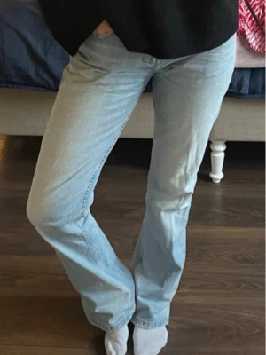 Ljusblå lågmidjade jeans med en liten utsvängning - Säljer mina snygga ljusblå jeans med en låg midja och en liten utsvängning nertill. Ja säljer dessa jeans då jag köpte dom på vinted och jag fick ej igen midjan på dom (bilderna är tagna av hon jag köpt av).  Jeansen har en enkel look utan slitningar och är perfekta för en avslappnad stil.  Tillverkade i mjukt denimtyg som ger en skön känsla hela dagen.