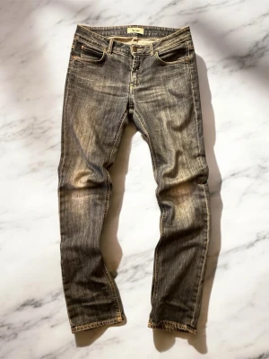Acne Studios blå jeans straight fit - Säljer ett par klassiska blå jeans från Acne Studios med straight fit och snyggt slitna detaljer. Jeansen har fem fickor, normal midja och är tillverkade i bomull med en autentisk tvättad look. Perfekta för en avslappnad och stilren vibe. Hör av dig vid minsta fundering och jag fraktar alltid en till två dagar efter beställningen! Pris kan diskuteras vid snabb affär😊