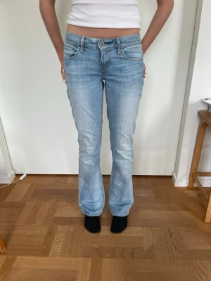 Levis 517 ljusblå bootcut jeans - Säljer ett par lågmidjade ljusblå Levis 517 jeans med klassisk bootcut passform. Perfekta för dig som gillar en avslappnad men ändå snygg stil. Ganska stretchiga.    Storlek 26 i midjan.  Jag på bilden 163-164cm lång. Midja ca 34cm Innebensmåttet ca 78cm