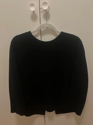 Svart omlott blus från Vince - Säljer en svart omlott blus med lång ärm. Blusem har en enkel, stilren look och omlottdetalj bak som ger en cool twist. Perfekt att slänga över en topp för en clean outfit. Blusen är i storlek US 4