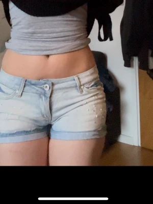 Ljusblå lågmidjade denimshorts med pärldetaljer - Säljer ett par ljusblå lågmidjade denimshorts med pärldetaljer framtill🩷 Perfekta till sommaren🙏 midjemått: 42cm tvärs över, totala längden: 24,5, grenlängd: 20,5cm och benöpningen: 28cm tvärs över💕 skriv om du har frågor🫶🩷