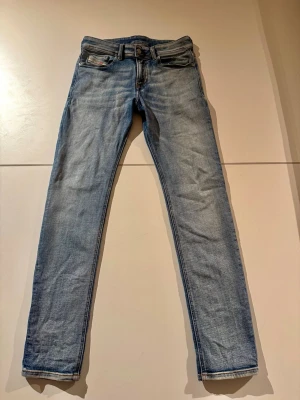 Ljusblå skinny jeans från Diesel - Snygga ljusblå skinny jeans från Diesel med klassisk femficksdesign och knappgylf. Jeansen har en smal passform och är tillverkade i mjukt bomullsjeansmaterial. Perfekta för en avslappnad och trendig look. NYPRIS 3000 kr 