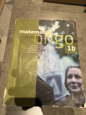 Matematik Origo 1b - Matematik Origo 1b är en kursbok för gymnasiet, perfekt för dig som läser matematik på högskoleförberedande program. Boken har ett grönt och blått omslag med tydlig titel och författarnamn på framsidan. Innehåller teori, övningar och exempel.