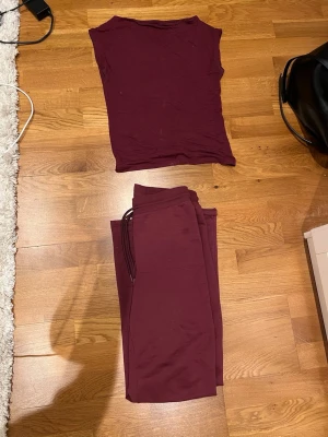 Vinröd ärmlös väst - Säljer en enkel och stilren vinröd set, superskönt och byxorna är low waist. Tröja xs och byxorna s