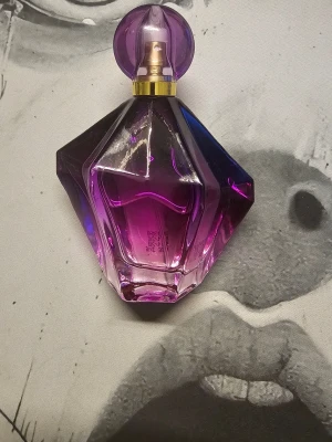 Shirley May Sassy Girl parfym 100ml - Säljer en Shirley May Sassy Girl parfym i en snygg lila och guld diamantformad flaska på 100ml. Doften har fruktiga toppnoter, blommiga hjärtnoter med jasmin och iris samt en söt bas av pralin. Perfekt för dig som gillar färgstarka och lekfulla dofter.