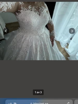 Vit lång bröllopsklänning med spets - Elegant vit långklänning med spetsdetaljer och broderier över hela livet och ärmarna. Klänningen har illusion neckline, långa ärmar i spets och en vid kjol med släp. Perfekt för dig som vill ha en klassisk och romantisk look. Helt ny bara testat aldrig använd. 