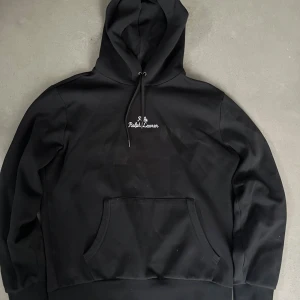 Ralph Lauren Hoodie - Snygg svart hoodie från Ralph Lauren med broderad logga på bröstet. Strl M och i mycket gott skick. Hör av er vid frågor eller funderingar! 
