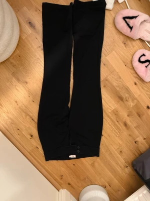 Svarta kostymbyxor från Nelly i storlek s  - Snygga svarta kostymbyxor från Nelly med klassisk rak passform och knappar framtill. Perfekta att styla med en skjorta eller topp för en clean look. Byxorna är gjorda i ett mjukt material som känns bekvämt hela dagen. Säljer för att den är för korta har används få gånger.