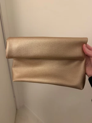 Guldig clutch från even & odd - Guldig clutch från even & odd som passar perfekt till festliga tillfällen 