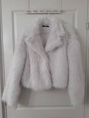 Vit fuskpälsjacka - Supersnygg vit fuskpälsjacka från Gina Tricot. Mjuk och fluffig med klassisk krage och kortare modell – perfekt till fest, utekvällar eller vardagsoutfit 🤍Trots att den är i storlek L sitter den jättebra på mig som vanligtvis har XS/S i toppar. Superfin passform!