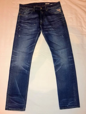 REPLAY PREMIUM JEANS – SJUK TVÄTT 🔥 | RIKTIG DENIM | STEAL - Helt brutala Replay premium jeans i mycket bra skick. En av de där modellerna där tvätten gör ALLT – djup indigo, perfekta whiskers, naturlig fading och grym patina. Ser dyra ut direkt på kroppen.  Tung kvalitetsdenim, snygg slim/straight passform och klassiska Replay-detaljer. Såna här jeans är svåra att hitta i den här nivån av wash + skick.  🧼 Otroliga tvättar 💎 Premium denim 🔥 Replay original – inga kompromisser  Mått: • Midja: 44 cm • Innerben: 82 cm • Längd: 104 cm • Benslut: 18 cm  Passar