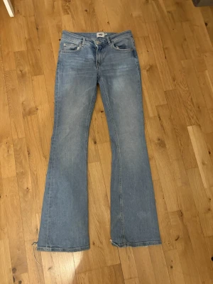 Ljusblå bootcut jeans med slits - Säljer ett par ljusblå bootcut jeans med slits nertill på benen. Klassisk femficksmodell i mjukt denimtyg, perfekt för dig som gillar en avslappnad och trendig look. Passar till det mesta och ger en snygg siluett.                  Kostar så lite pågrund av att vill få solt dom snabbt 